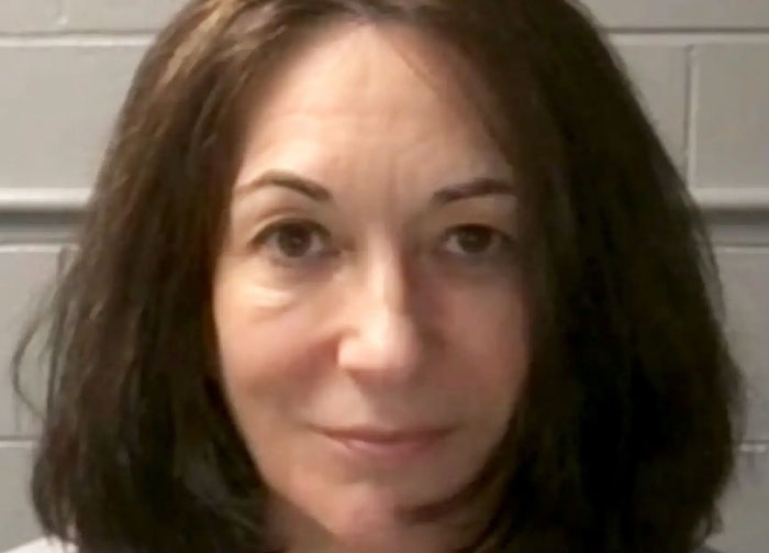 A woman with dark hair and a slight smile looks directly at the camera, generating controversial beliefs.