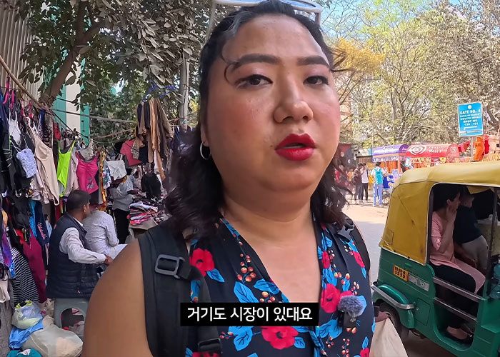 Korean man disguised as pregnant woman in India market scene
