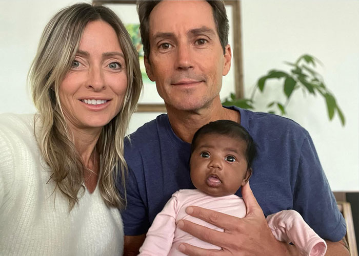 A happy couple smiling with the baby they gave birth to after an IVF mix-up, keeping her after striking a deal. A happy couple smiling with the baby they gave birth to after an IVF mix-up, keeping her after striking a deal.