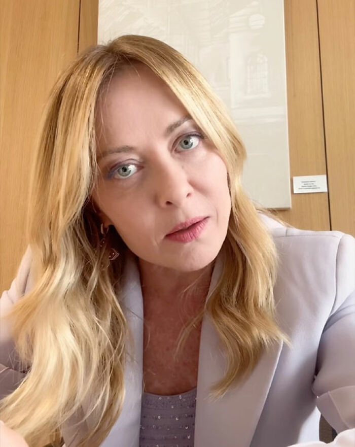 Italian PM Giorgia Meloni with blonde hair, looking directly at the camera. She broke silence after Trump's comment.
