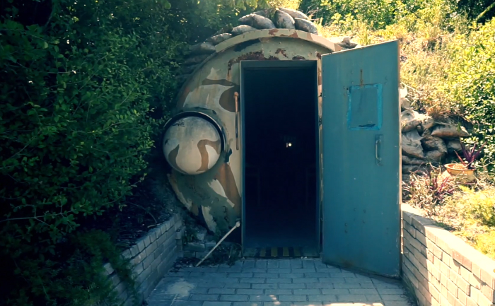 John F. Kennedy's Detachment Hotel. Camouflaged underground bunker entrance with open blue door