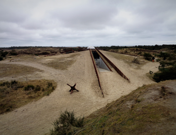 The Tirpitz Bunker. Secret underground bunker entrance hidden in sandy terrain under cloudy sky