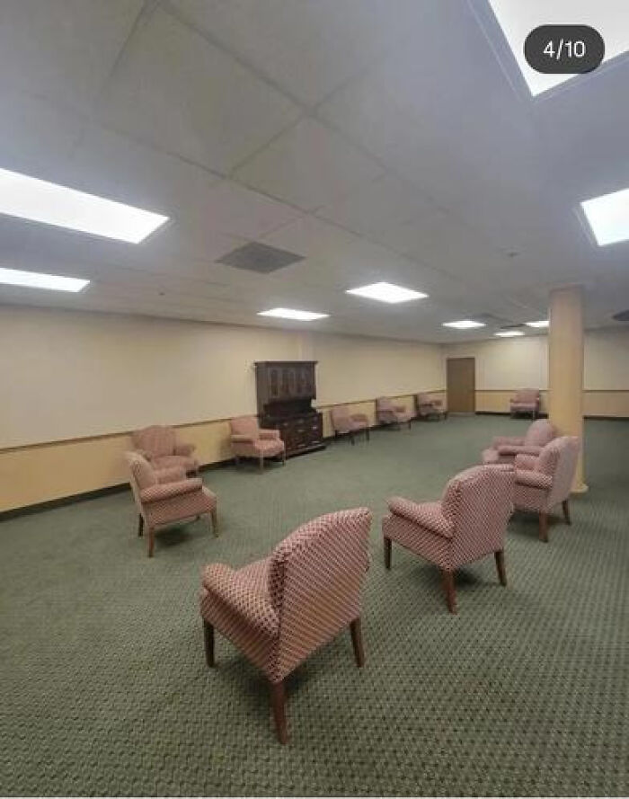 An empty room with numerous chairs arranged in a circle, evoking a haunting liminal space.
