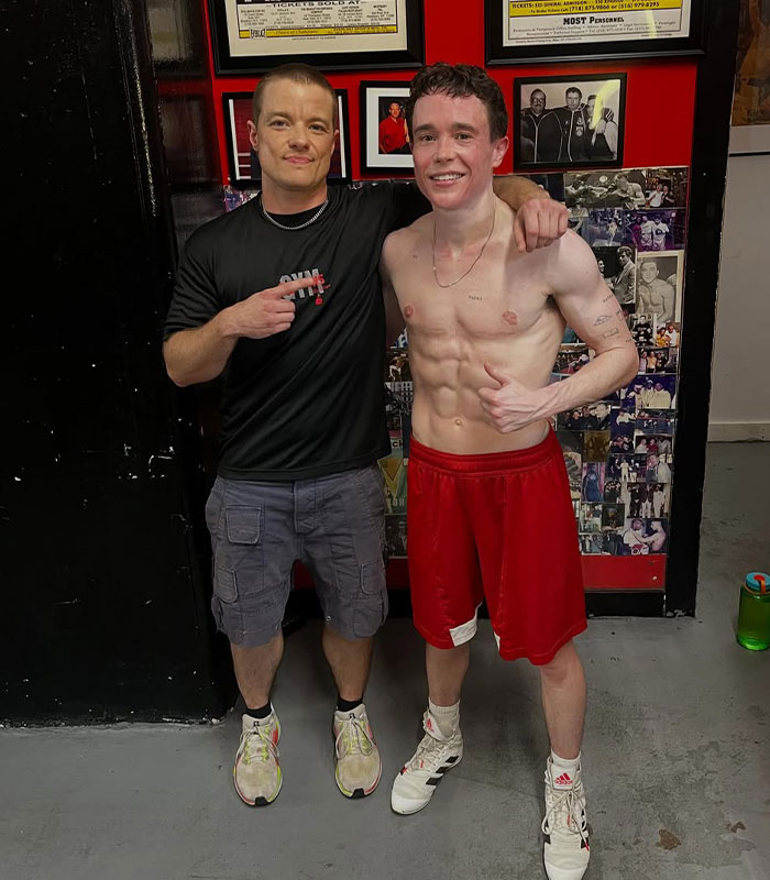 Elliot Page shows off shredded physique, posing with a trainer in a boxing gym. His boxing journey is inspiring.