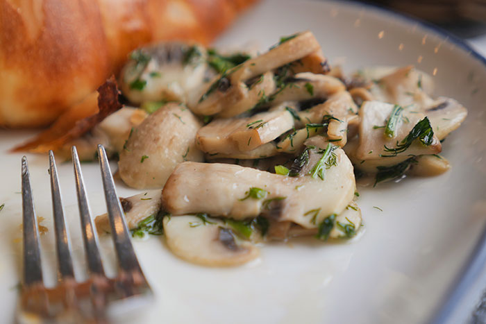 Close up of sautéed mushrooms on a plate with bread Close up of sautéed mushrooms on a plate with bread
