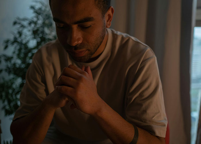Man praying or reflecting in low light symbolizing wild secrets taken to graves