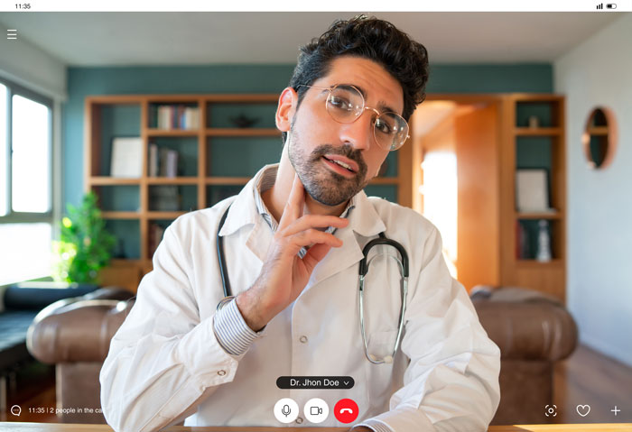 Doctor consulting patient over video call in home office setting