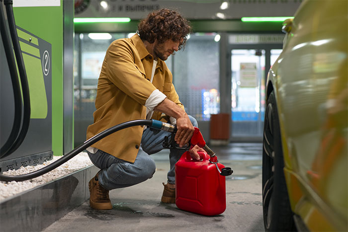 Person filling gas can at fuel station showing generous support in need