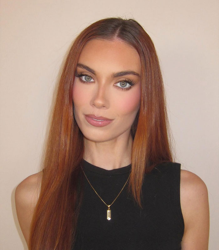 Woman with long red hair and makeup wearing black top and necklace Woman with long red hair and makeup wearing black top and necklace