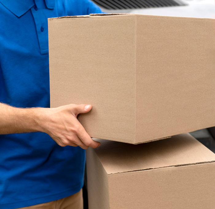 Delivery person holding stacked cardboard boxes