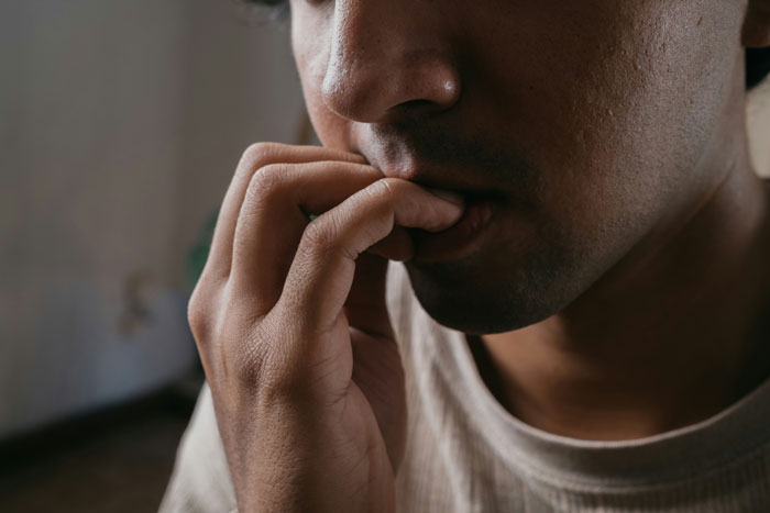 Man biting nails showing anxious and gross activities in relationships