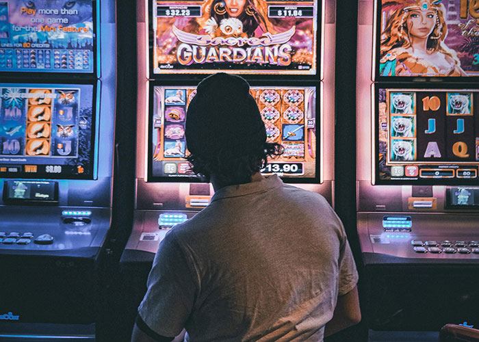 Man gambling on slot machines symbolizing a*******n life mistakes