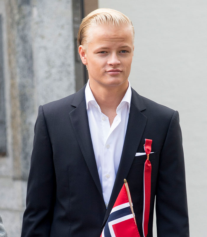 Son of Norway's future queen in formal suit holding Norwegian flag