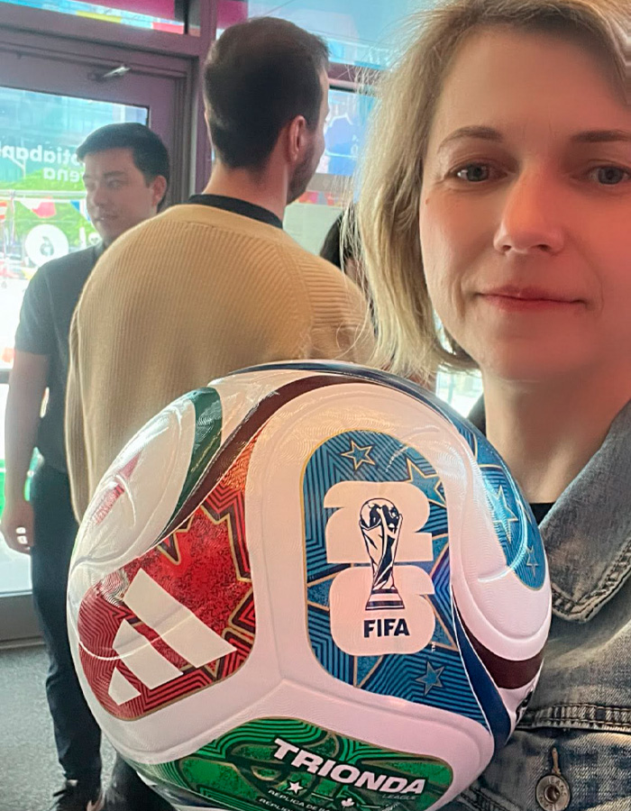 Woman holding official FIFA World Cup 2026 soccer ball indoors