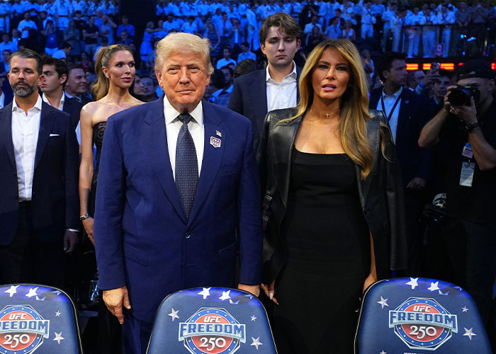 Donald Trump and Melania Trump attending UFC event with Barron Trump in background Donald Trump and Melania Trump attending UFC event with Barron Trump in background