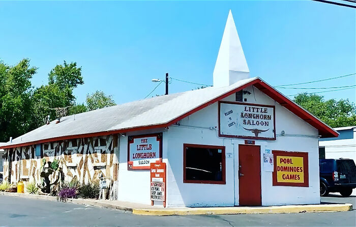 Little Longhorn Saloon bar with white steeple and signs for pool and dominoes games