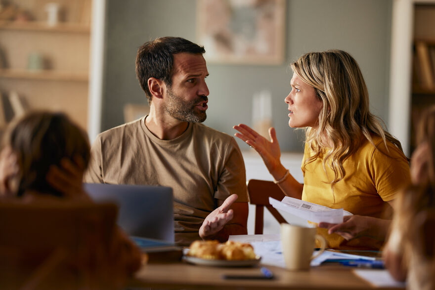 Couple arguing intensely during family conflict resolution discussion at home