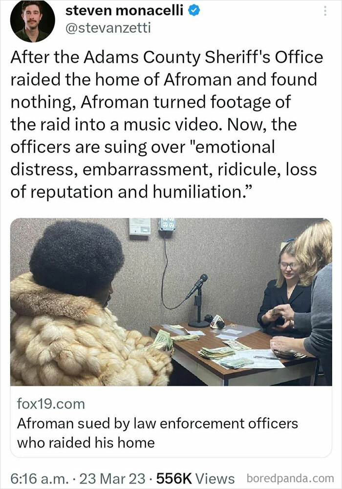 Afroman in a fur coat at a table, turning a raid into a music video, a true mad lad.