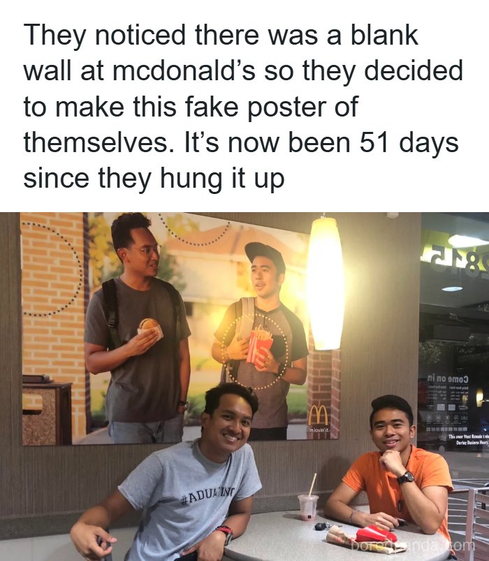 Three men smiling in front of their fake poster at McDonald's, a personal challenge for these mad lads.