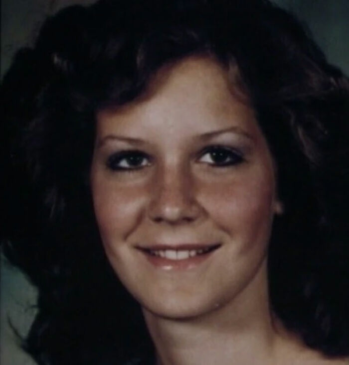 A young woman with curly brown hair smiles, a face connected to unsolved mysteries.