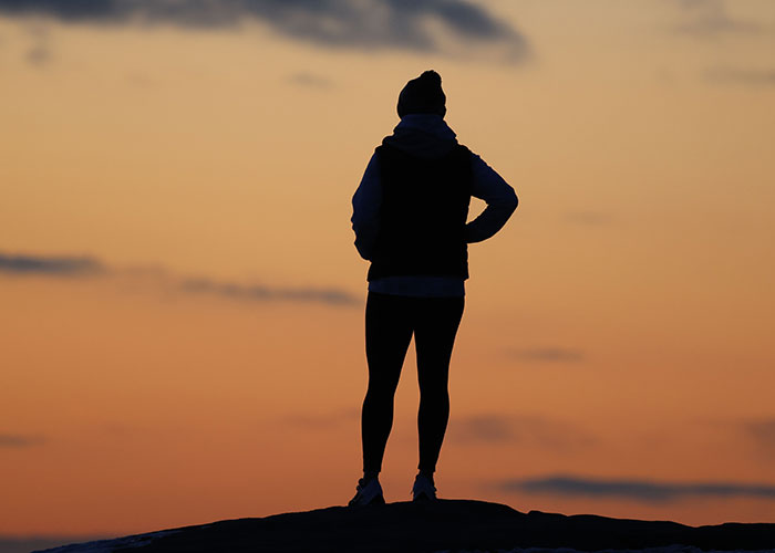 A silhouette of a person on a hill at sunset, symbolizing embracing advice that is good but socially not acceptable.