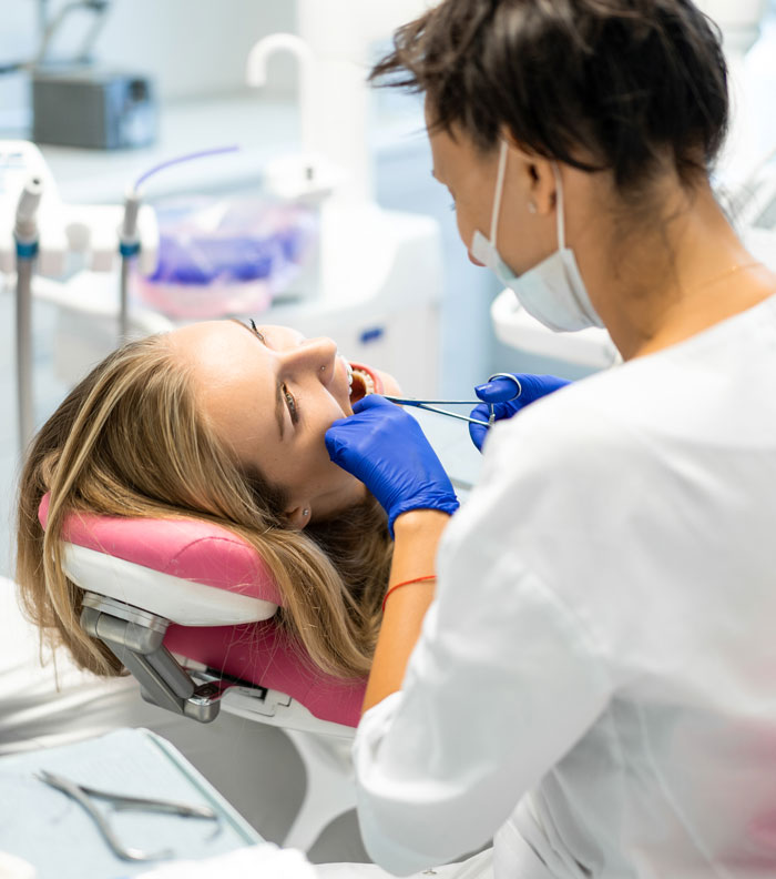 Dentist examining patient teeth during dental appointment in clinic
