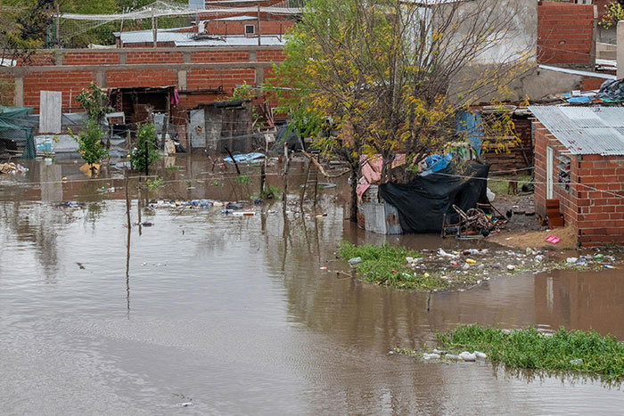 Flooded neighborhood showing water damage and debris near brick houses