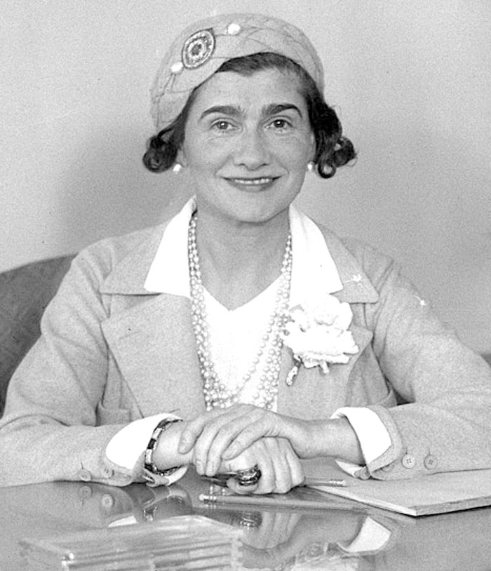 Black and white portrait of smiling romanticized historical figure wearing pearls