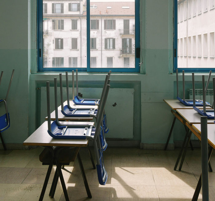 Empty classroom with chairs placed upside down on desks