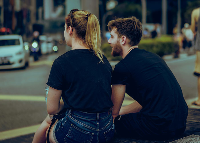 Couple sitting by street, legal offense awareness concept