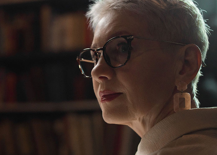 Mature woman with glasses in thoughtful pose