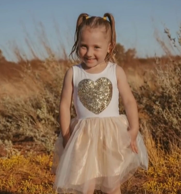 Smiling 4-year-old girl wearing dress outdoors in dry grassland Smiling 4-year-old girl wearing dress outdoors in dry grassland
