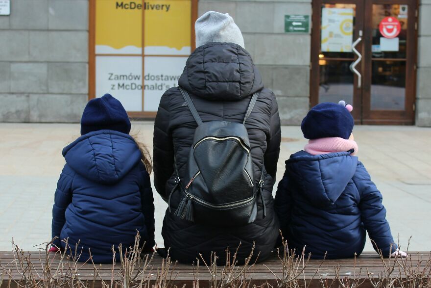 Parent with two children sitting on bench symbolizing family dynamics in relationships