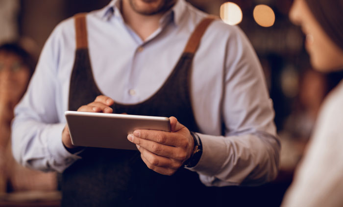 Waiter taking order on tablet showing interaction raised by Karens