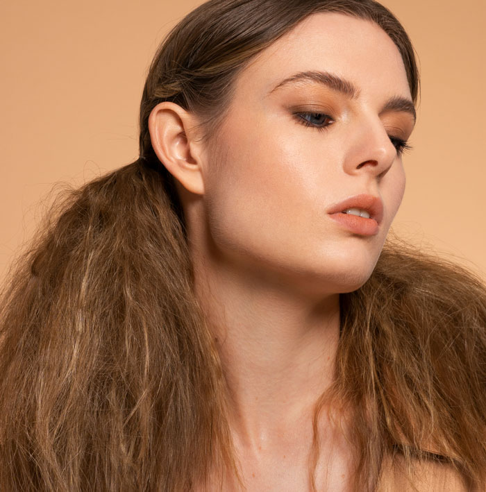 Close-up of woman with styled hair and makeup reflecting on body image