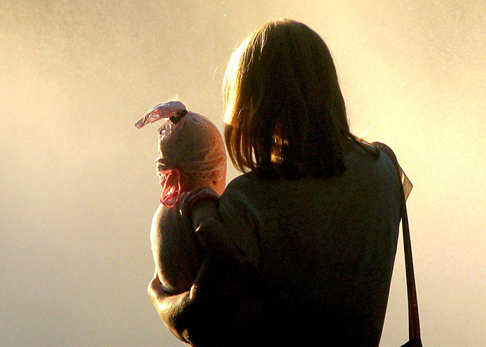 Silhouette of a parent holding a baby, representing the precious contact kids have with their parents.