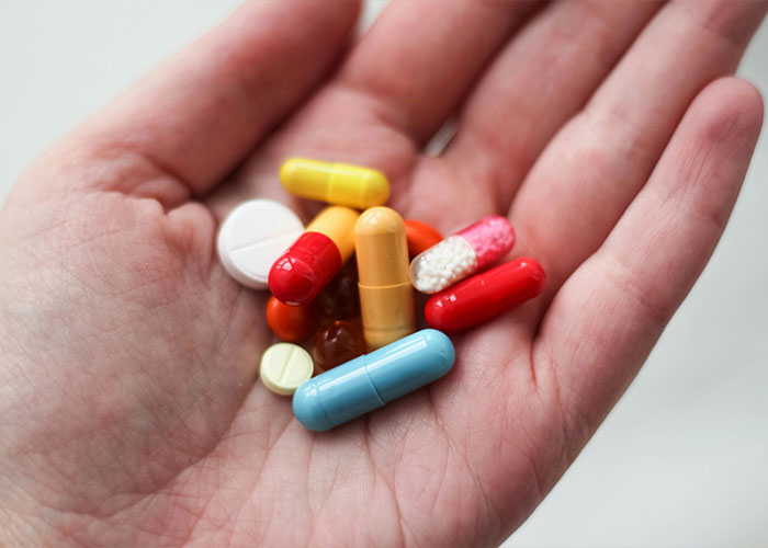 Hand holding colorful medication pills and capsules for brain health Hand holding colorful medication pills and capsules for brain health