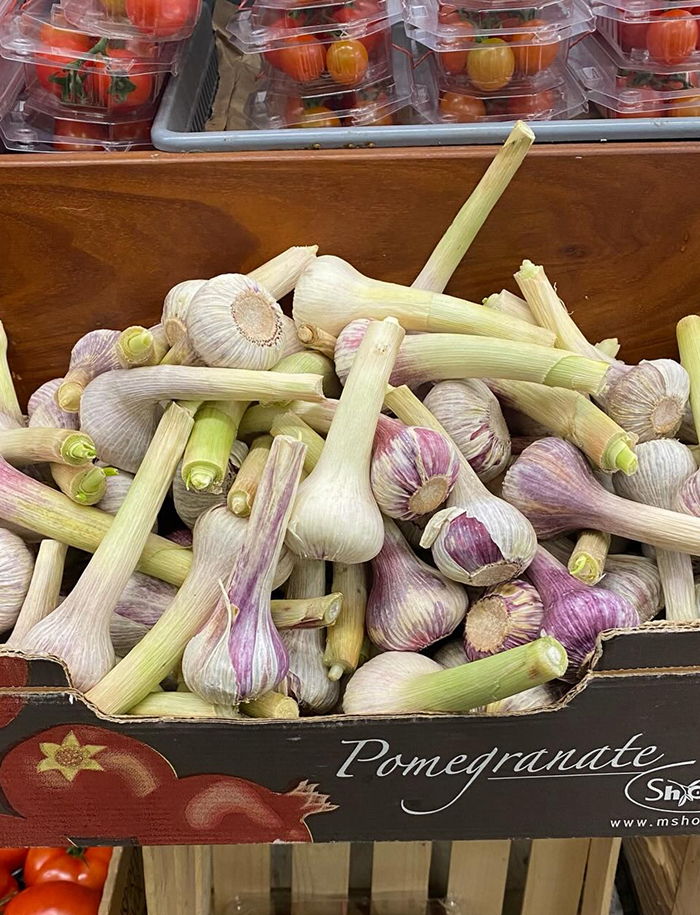 Fresh garlic bulbs in a crate at a market, highlighting cooking myths about flavoring dishes
