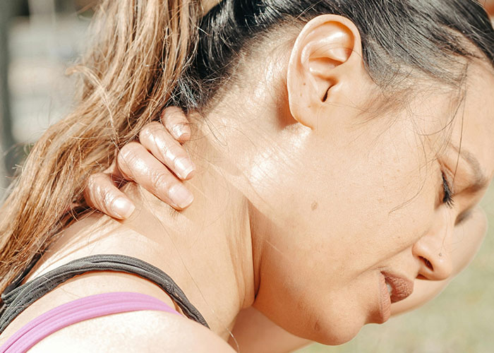 Woman massaging neck in pain showing life mistakes impact
