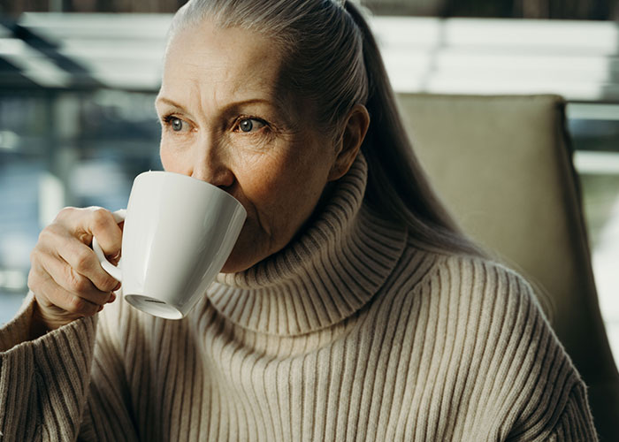 Older woman sipping coffee in contemplative mood