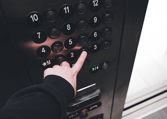 Person pressing elevator button moment to leave immediately