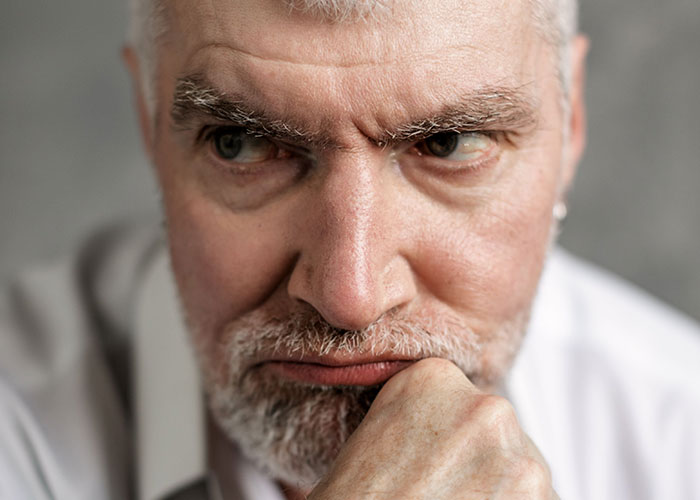 A man with a grey beard and furrowed brow looks away, reflecting on moments kids can't keep contact with parents.