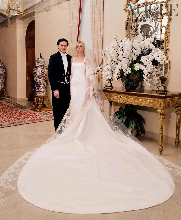 Nicola Peltz Beckham poses elegantly in her stunning celebrity wedding dress, with husband Brooklyn Beckham, showcasing a classic and sophisticated bridal look.