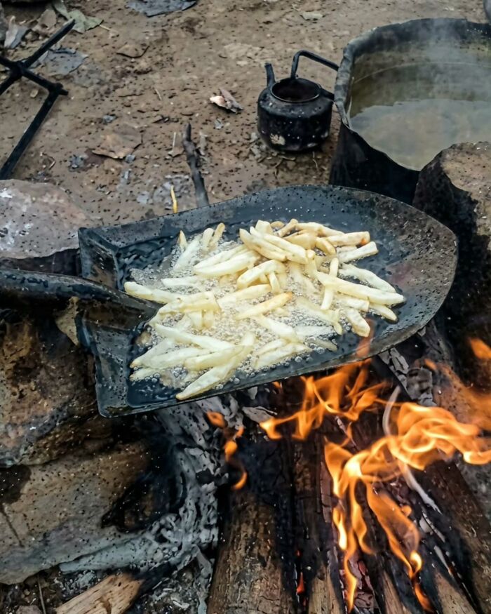 A shovel frying french fries over an open campfire, showcasing examples of Slavic science and ingenuity.