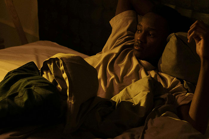 Man awake in bed unable to sleep at night in dark bedroom
