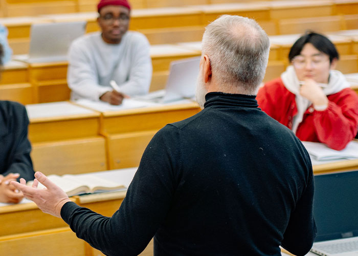 Professor teaching students in a classroom setting, educational environment