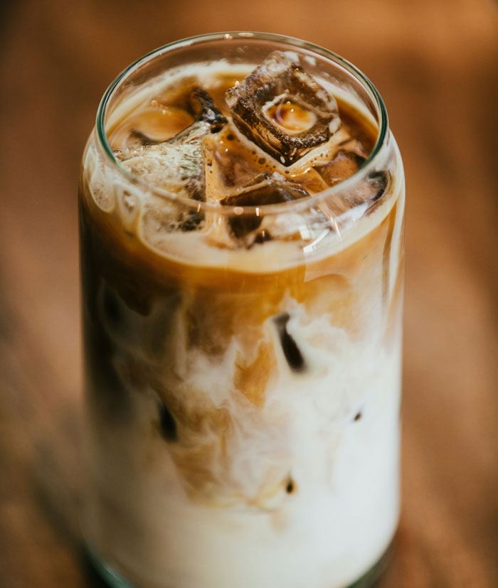 Iced coffee with milk and ice cubes in a glass closeup