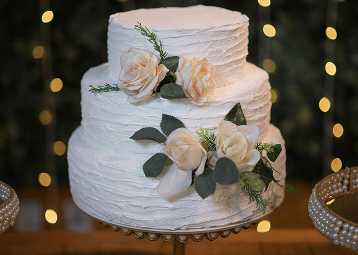 Wedding cake decorated with flowers on stand