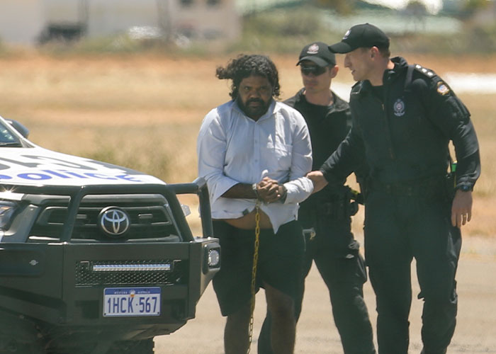Man in handcuffs escorted by police near vehicle in missing girl case Man in handcuffs escorted by police near vehicle in missing girl case