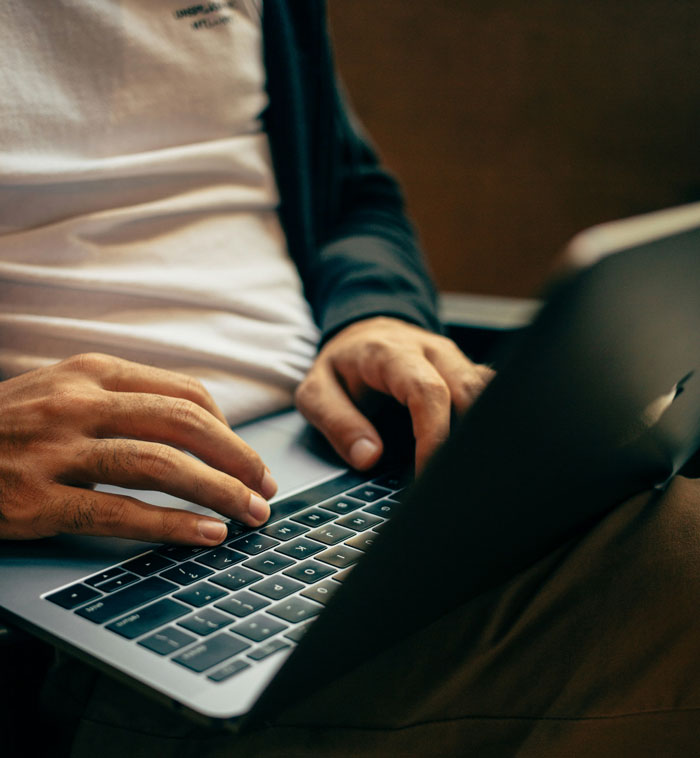 A person using a laptop, possibly researching or sharing DNA testing stories and experiences.